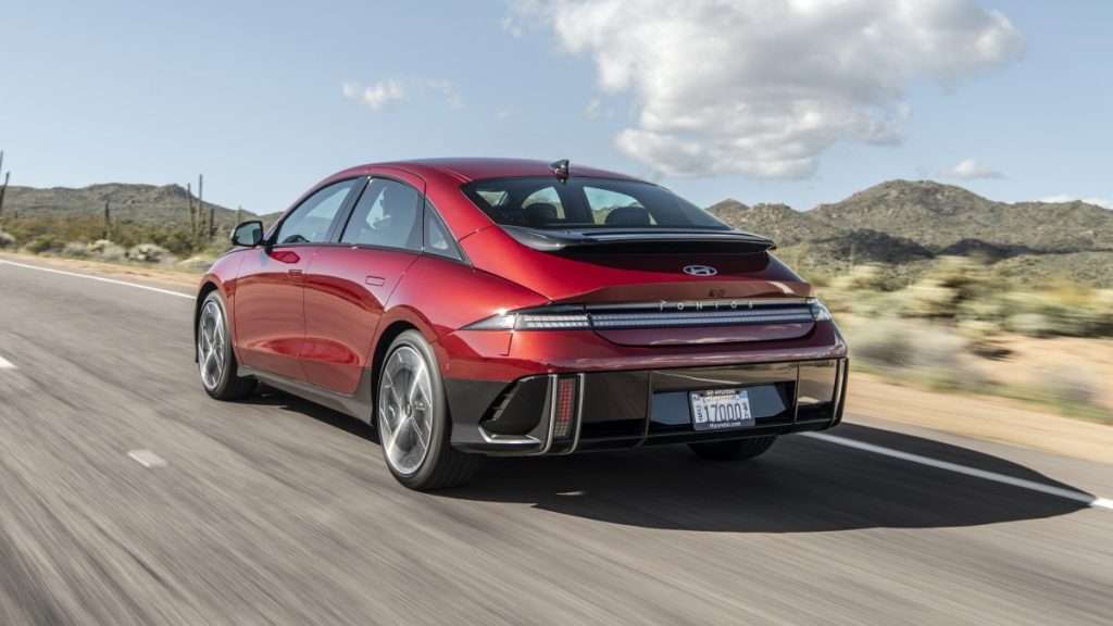 Rear side view of a 2025 IONIQ 6 Limited driving on a road