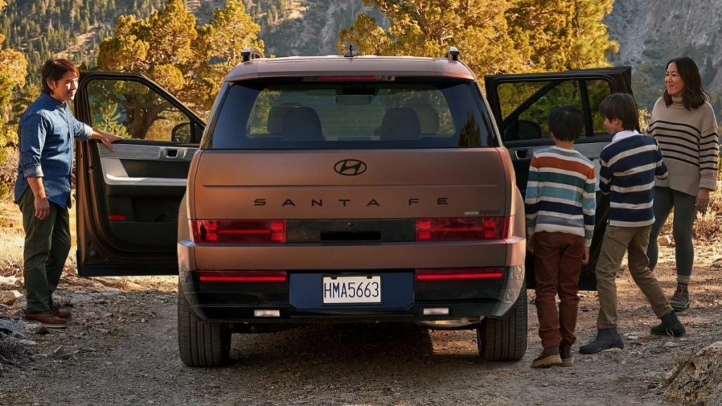 Rear view of a 2025 Hyundai Santa Fe Hybrid with a family getting into the SUV
