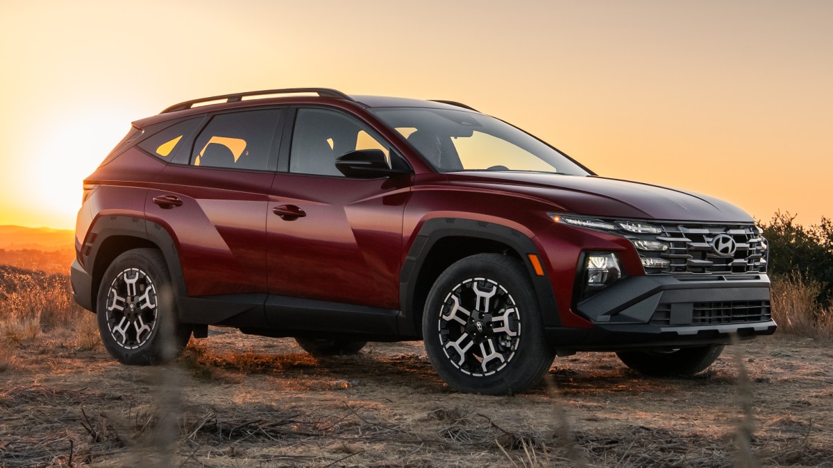 Front side hero view of a red 2025 Hyundai Tucson XRT parked off-road
