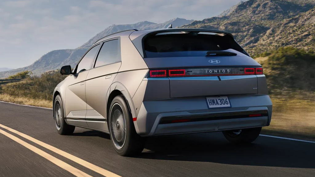 2025 IONIQ 5 in Gravity Gold Matte Rear exterior view driving on road
