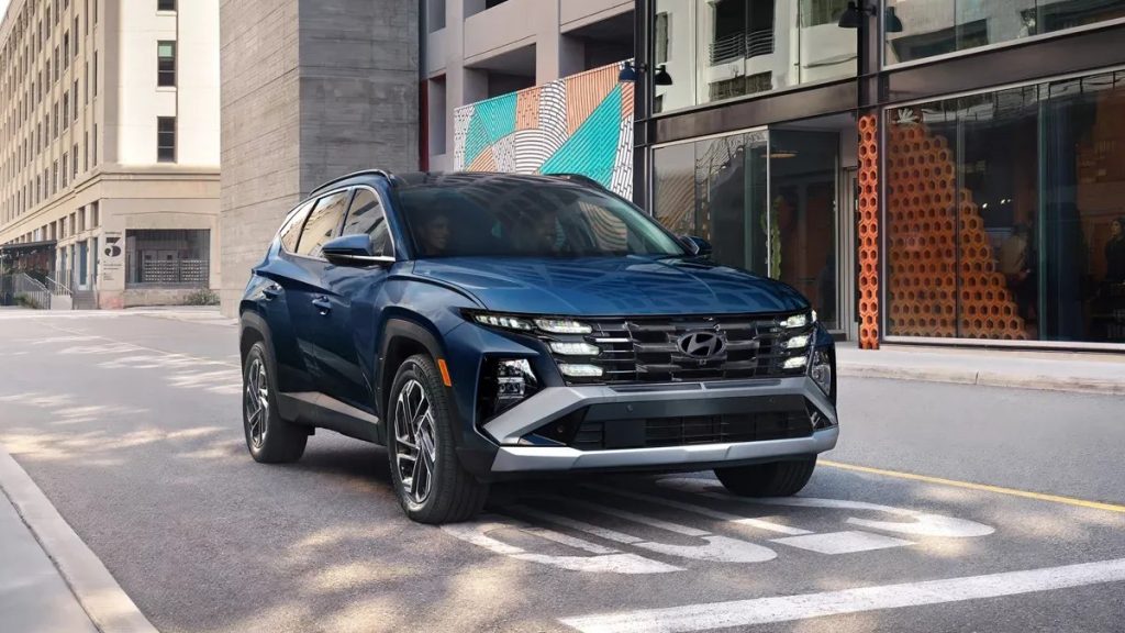 Front side hero view of a 2026 Hyundai Tucson driving on a city street