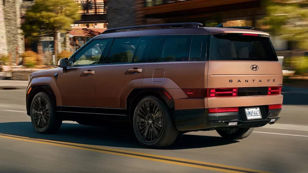 Earthy Brass Matte 2026 SANTA FE Hybrid Limited driving in a city.